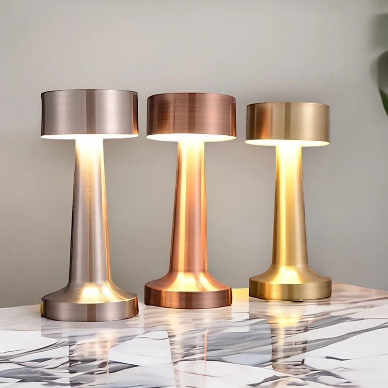 Trois lampes nomades LUMORA en métal brossé argent, cuivre et or, sans fil, tactiles et à lumière blanc chaud.