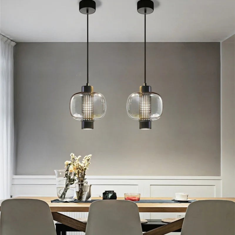 Suspension design LUMORA Bolla en verre soufflé transparent et métal noir mat au-dessus d'une table de salle à manger